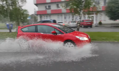 Auto prechádza ulicou A. Hlinku v Piešťanoch počas silného prívalového dažďa 3. júna 2024