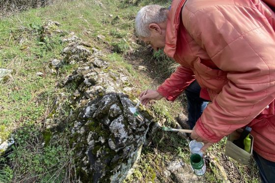 Značkár maľuje značku pri jaskyni Mníchova diera v Smolenickom krase